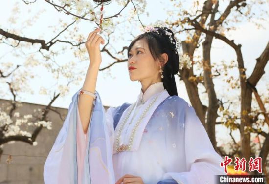 圖為蘭州青年身穿漢服在百年梨園賞景?！「哒?攝