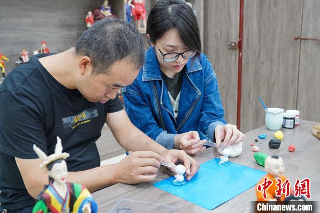 <a target='_blank'  data-cke-saved- >中新社</a>記者(右)現(xiàn)場(chǎng)體驗(yàn)面塑制作過(guò)程。　陳爭(zhēng)強(qiáng) 攝