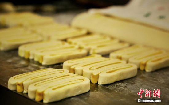 圖為面劑被涂上胡麻油，切成條狀用作月餅的花型制作。張文 攝