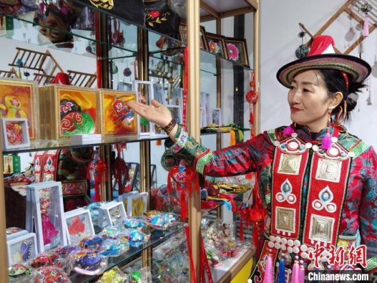 圖為身著民族服飾的隴原巧手展示手工藝品。(資料圖) 徐雪 攝