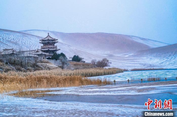2021年11月28日，雪落鳴沙山月牙泉景區(qū)?！⊥醣筱y 攝