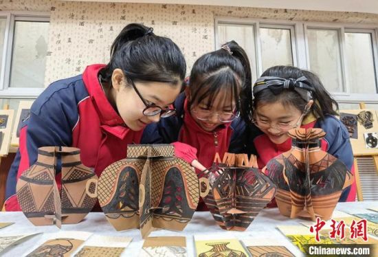 圖為學(xué)生用紙創(chuàng)作的立體彩陶?！⒂裉?攝