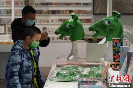 圖為“神馬來了”銅奔馬頭套吸引參觀者駐足?！【琶赖┰?攝