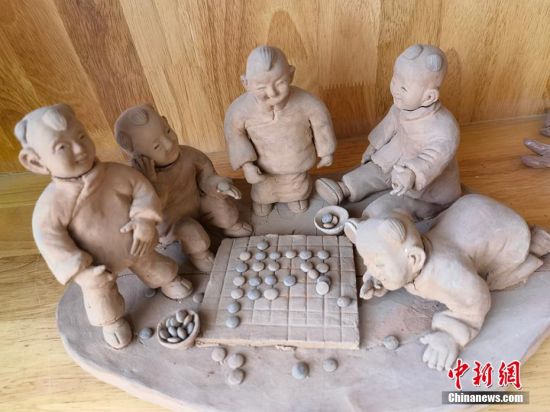 圖為泥塑作品展現(xiàn)下棋場(chǎng)景。 劉玉桃 攝