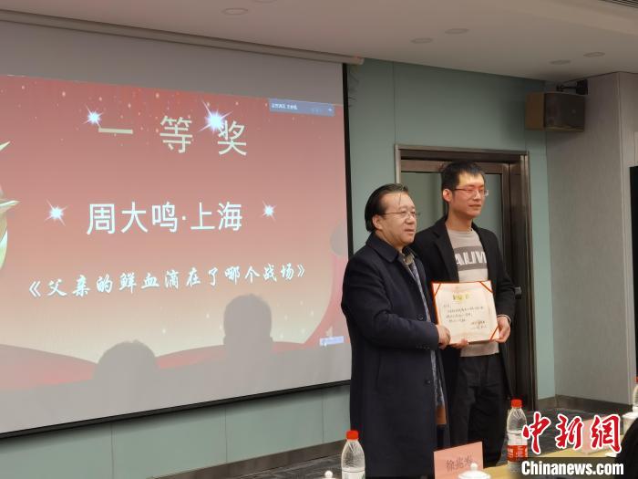 圖為作家、西北師范大學(xué)新聞與傳媒學(xué)院院長(zhǎng)徐兆壽頒發(fā)一等獎(jiǎng)證書(shū)，代領(lǐng)獎(jiǎng)?wù)呱吓_(tái)領(lǐng)獎(jiǎng)。　楊娜 攝