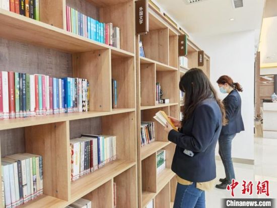 圖為在甘肅公航旅建設(shè)集團有限公司的職工書屋，職工挑選書籍。　徐雪 攝