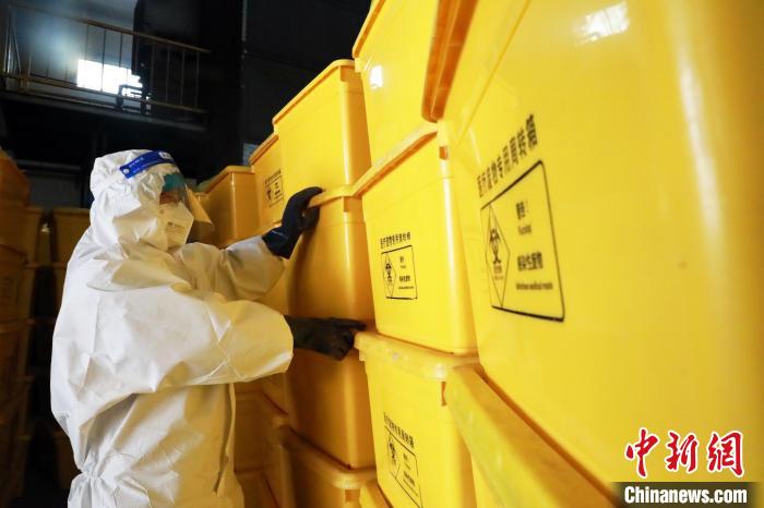 圖為工作人員搬運(yùn)醫(yī)療廢物專(zhuān)用周轉(zhuǎn)箱?！∥航ㄜ?攝