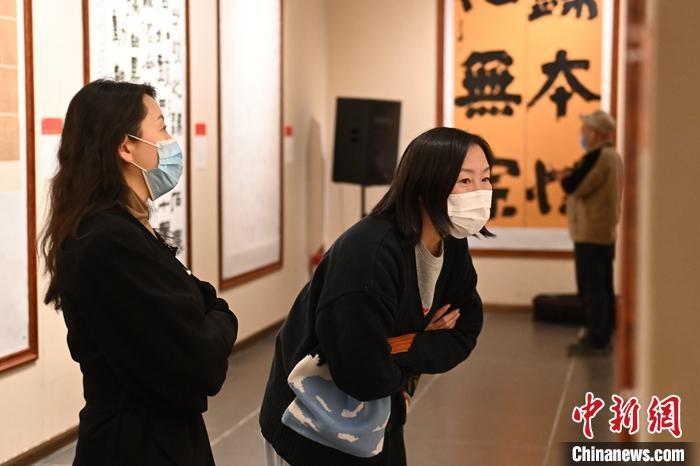 圖為甘肅蘭州，參展書(shū)法作品吸引參觀者。 中新社記者 李亞龍 攝