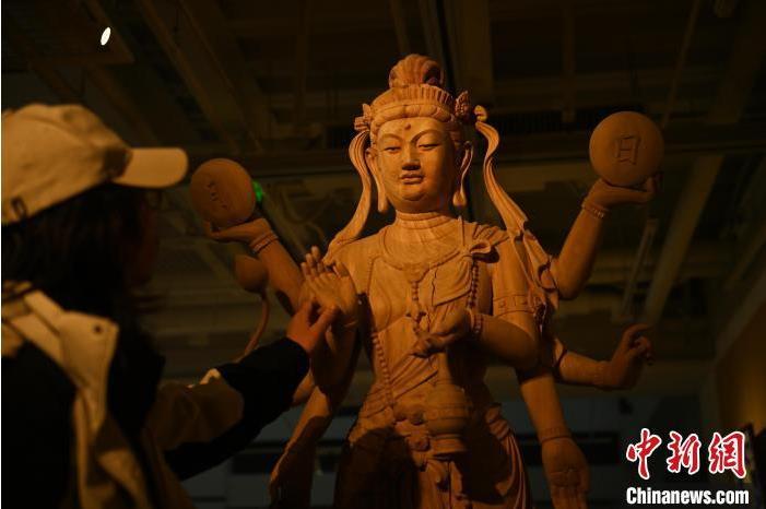 圖為季茂杰觀察自己創(chuàng)作的敦煌木雕。李亞龍 攝</p>
<p>