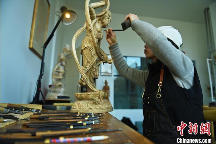 圖為季茂杰進(jìn)行敦煌元素的木雕創(chuàng)作。李亞龍 攝</p>
<p>