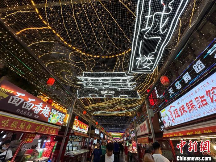 圖為明清街夜市燈光點(diǎn)亮具有武威文化元素的“涼州古城門(mén)”彩燈?！〈魑牟?攝</p><p>