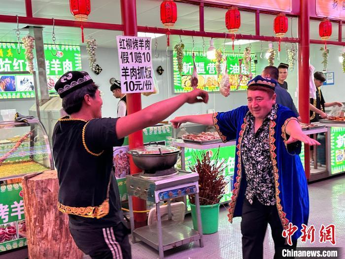 圖為餐飲經(jīng)營(yíng)者在“西涼不夜城”跳起舞蹈引客。　戴文昌 攝</p><p>