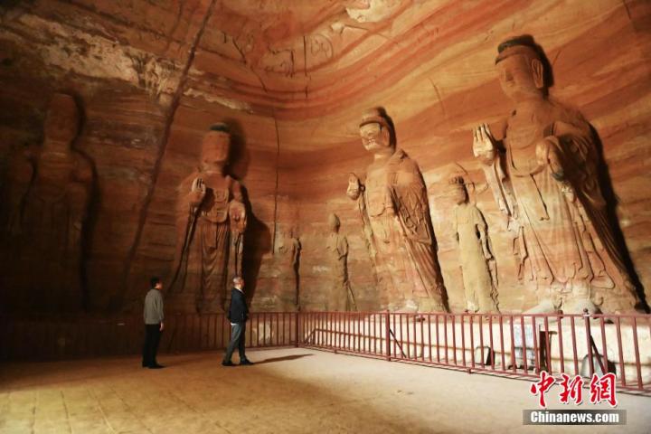 7月15日，游人參觀甘肅省平?jīng)鍪袥艽h百里石窟長(zhǎng)廊中的南石窟寺1號(hào)窟。百里石窟長(zhǎng)廊位于涇川縣境內(nèi)，由512個(gè)石窟、5眼窟中石井組成，現(xiàn)存王母宮石窟、鳳凰山石窟、南石窟寺、丈八寺石窟、羅漢洞石窟、太山寺石窟等規(guī)模較大的石窟群，還有數(shù)量眾多的小石窟群。南石窟寺開鑿于北魏永平三年，其中1號(hào)窟屬于大型七佛窟，七佛高達(dá)6米。中新社記者 李亞龍 攝