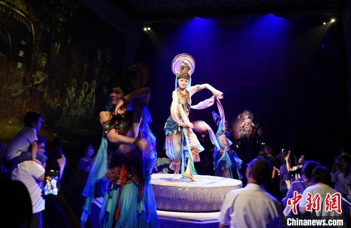 《樂動(dòng)敦煌》是全球首部洞窟式沉浸體驗(yàn)劇，利用真人與數(shù)字影像虛實(shí)交換實(shí)現(xiàn)沉浸式體驗(yàn)。圖為2023年8月28日晚，《樂動(dòng)敦煌》演出。(資料圖)中新社記者 毛建軍 攝